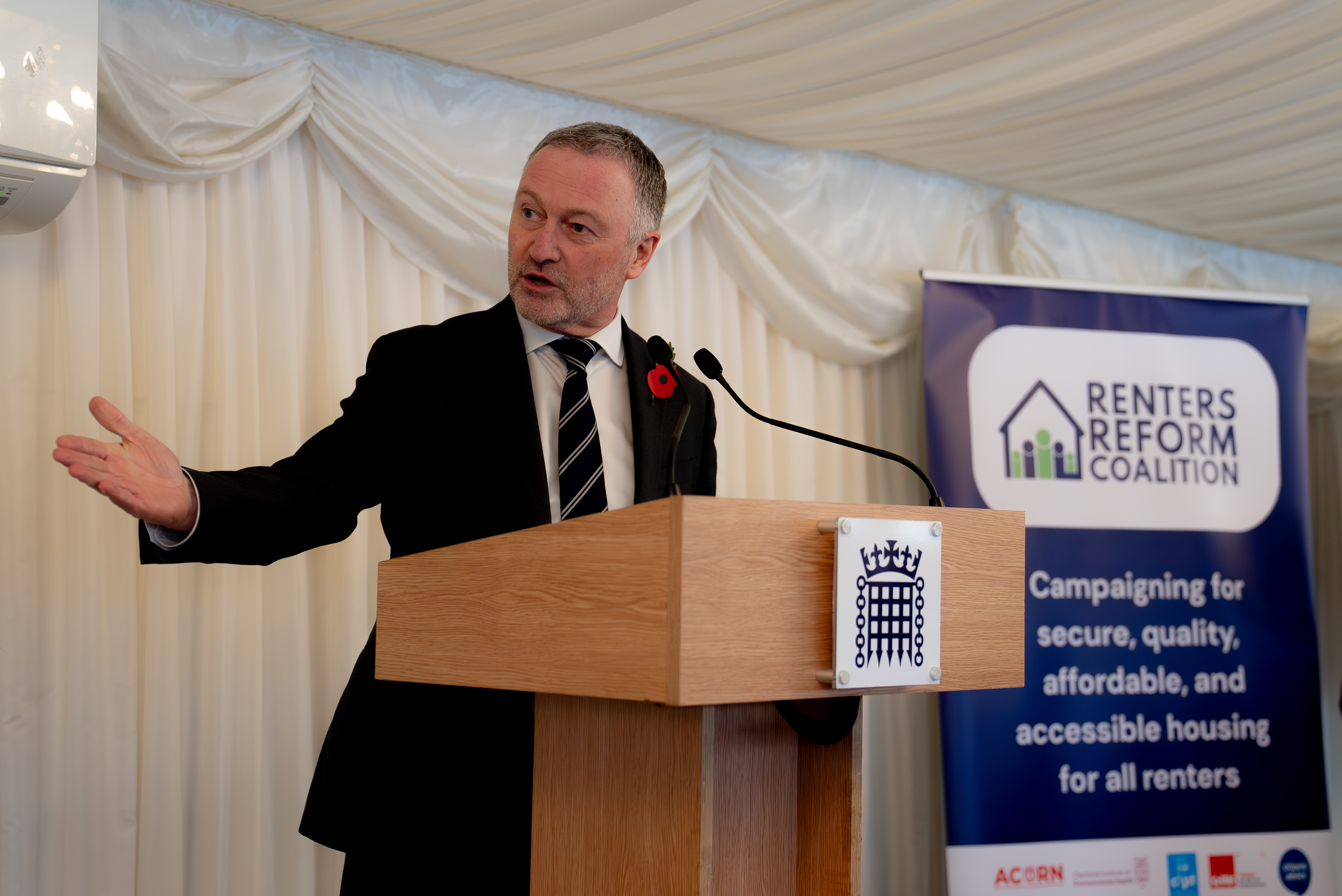Steve Reed speaks at a lectern his right hand indicating out