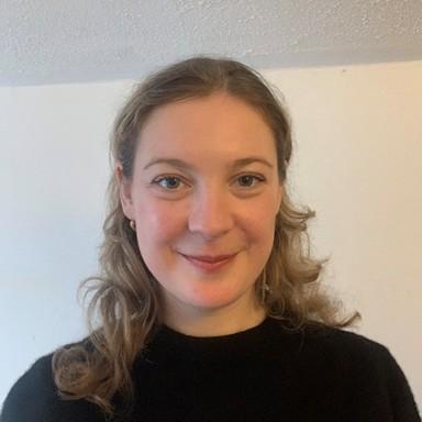 A photo of Clara Collingwood, a white woman with long blonde hair smiling at the camera